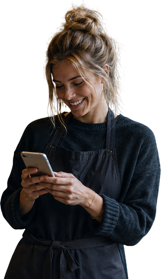 Small business owner smiling while checking new customer messages on her phone